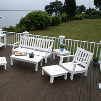 White outdoor furniture set on a wooden deck, featuring a sleek, minimalist design and a serene waterfront backdrop.