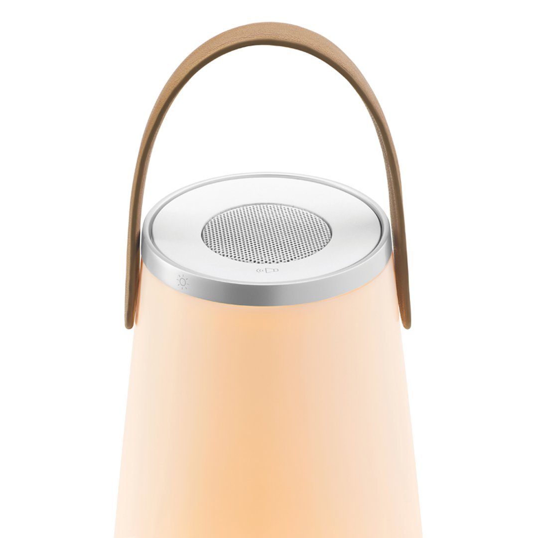 Peach-colored lantern with a sleek silver top and a stylish leather handle. Simple, modern design with soft hues.