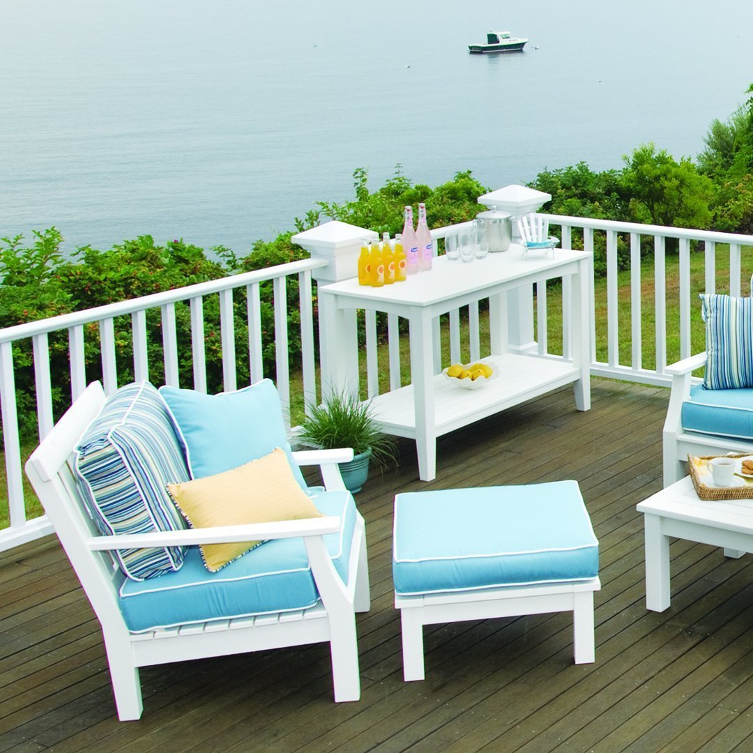 "Blue and white patio furniture with striped and solid cushions, set against a serene outdoor backdrop."