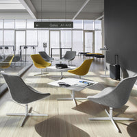 Modern lounge chairs in gray and yellow, with sleek metal bases, set in a bright, airy, contemporary space.