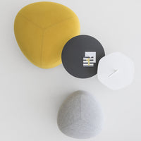 Colorful seating pillows in yellow, gray, and a round black and white table with modern geometric patterns.
