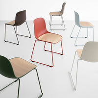 Colorful modern chairs in various hues: red, green, blue, grey, and black with chic wooden seats and sleek metal legs.