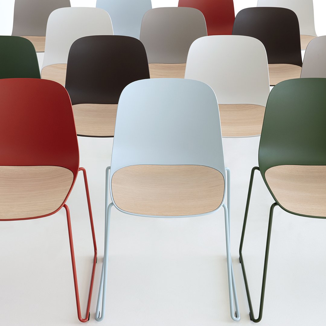 Colorful modern chairs in red, blue, green, brown, and white with wood accents. Sleek, durable, and stylish design.