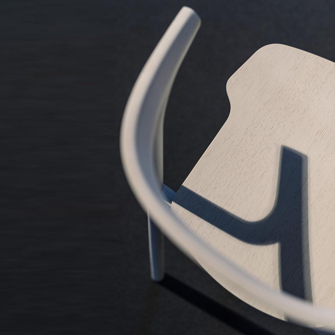 Sleek white chair with a smooth finish and soft, curved edges against a dark background, highlighting shadows.