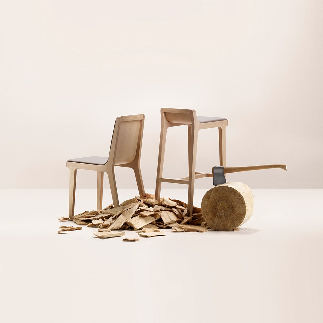 Natural wood chairs in soft beige, set against a neutral backdrop with wood shavings and a log.