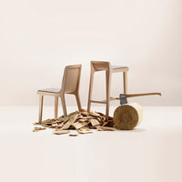 Natural wood chairs in soft beige, set against a neutral backdrop with wood shavings and a log.