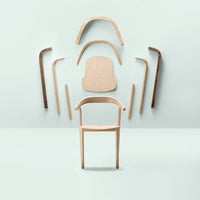 Light wood chair with smooth textures, surrounded by curved wooden components in natural and dark wood tones against a pale background.