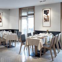 Elegant dining room with neutral-toned tables and chairs, featuring light wood and soft beige fabrics in a minimalist design.