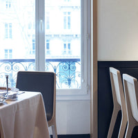 "Modern gray chair with clean lines, soft beige tablecloth, and subtle black accents in a bright, airy dining space."