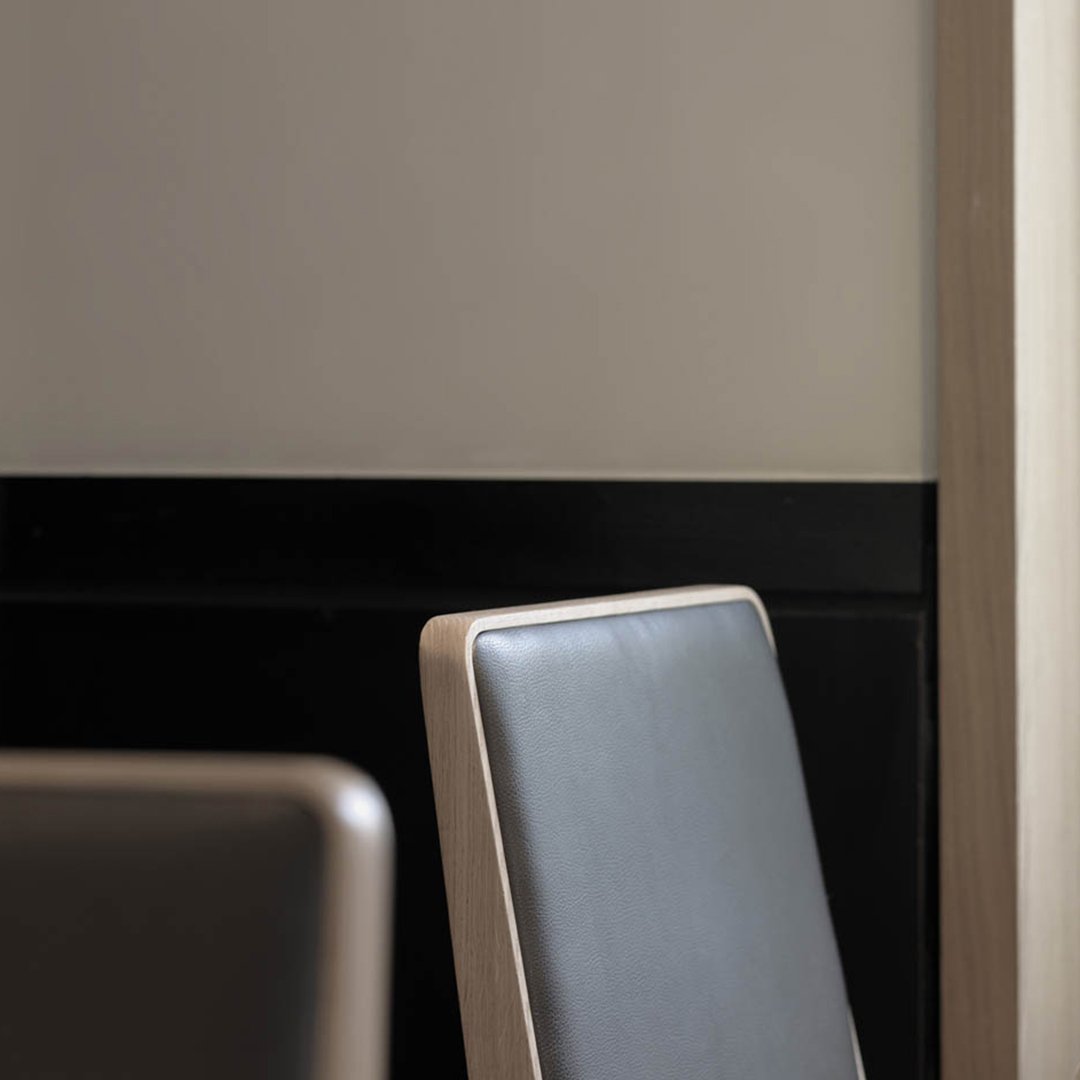 Black and gray chair with sleek, modern design against a neutral wall for contemporary decor.
