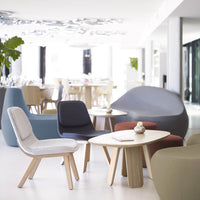 Modern seating arrangement featuring a mix of soft gray, navy blue, deep red, and muted green tones, with natural wood accents.