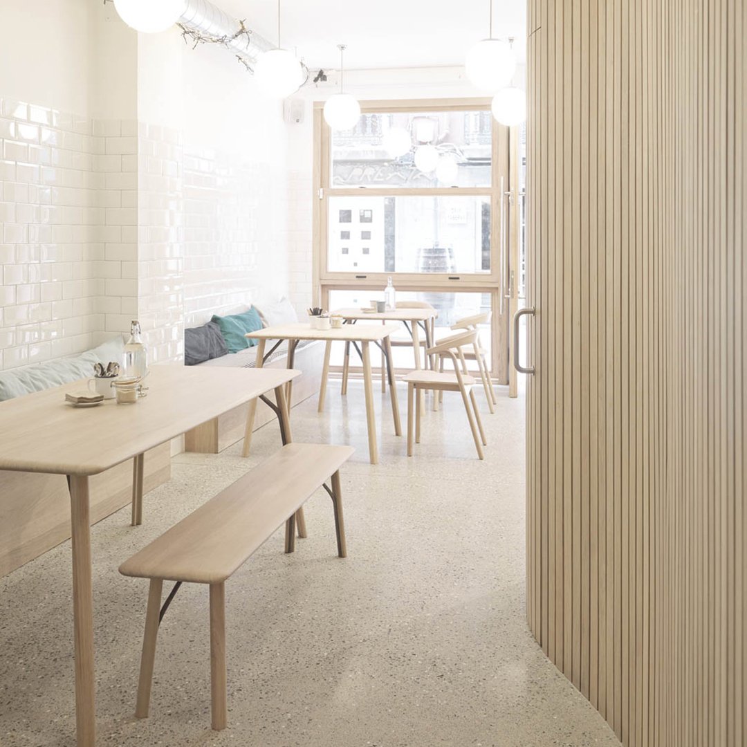 Light wood furniture with a minimalist design, soft beige tones, and a glossy white tile wall pattern.