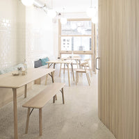 Light wood furniture with a minimalist design, soft beige tones, and a glossy white tile wall pattern.