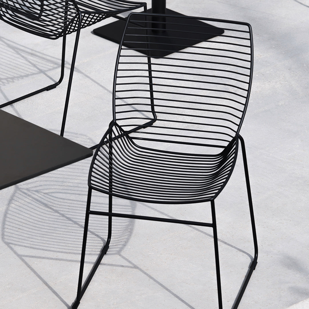 Black wire chair with a sleek, minimalist design featuring vertical and horizontal stripes. Perfect for modern decor.