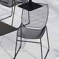 Black wire chair with a sleek, minimalist design featuring vertical and horizontal stripes. Perfect for modern decor.