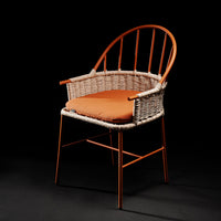 Orange cushioned chair with a woven rattan back and legs in warm copper tones. Stylish and modern design.