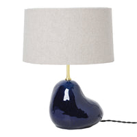 Navy blue ceramic lamp base with a smooth, organic shape and a light gray fabric shade. Elegant design for modern decor.