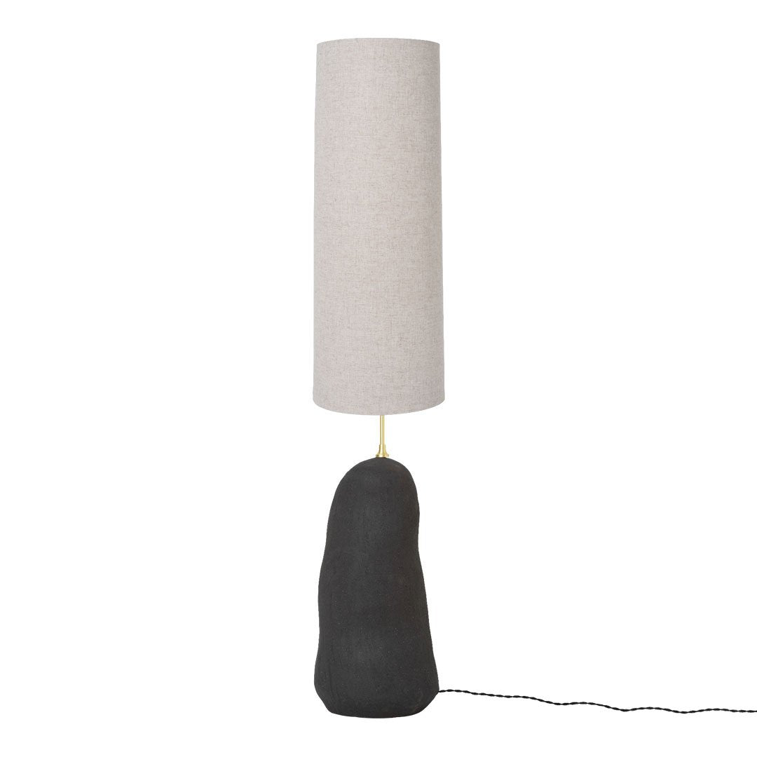 Minimalist lamp with a textured black base and a sleek, cylindrical beige shade. Perfect for modern decor.