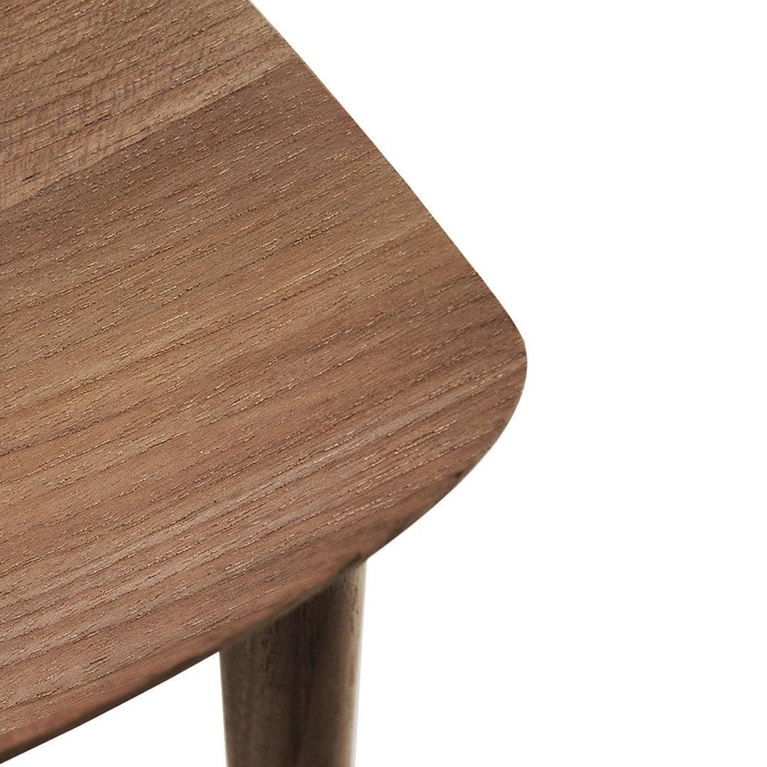 Close-up of a smooth, warm brown wood surface with a curved edge and subtle grain pattern, highlighting natural textures.