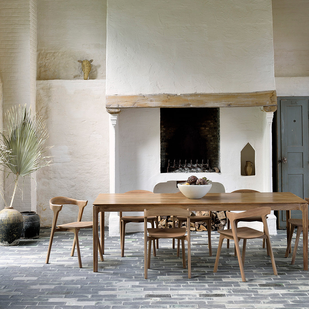 Warm wooden tones and natural textures against a soft neutral backdrop, with a patterned stone floor.
