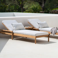 "Light gray lounge chairs with patterned cushions and natural wood frames, set against a minimalist outdoor backdrop."
