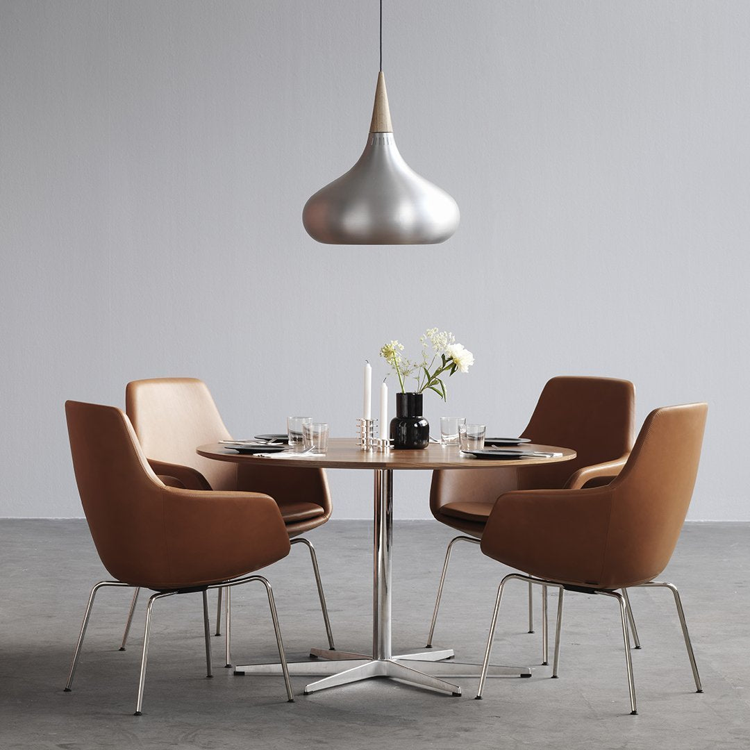 Modern dining set with brown leather chairs and a sleek silver pendant light, featuring a minimalist round table.