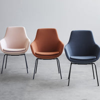 Trio of modern chairs in soft pink, warm orange, and deep blue with sleek metal legs, perfect for contemporary decor.