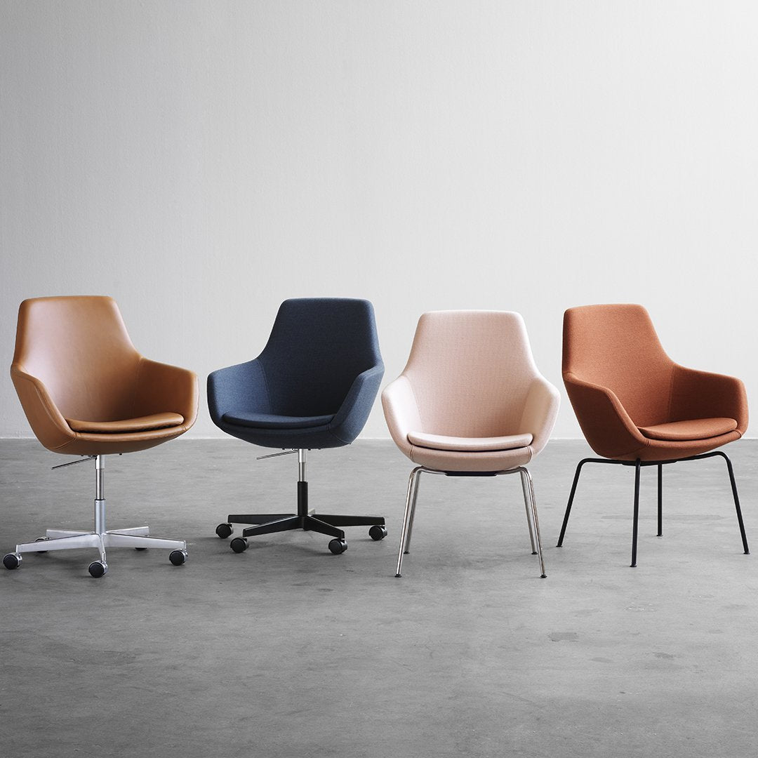 Four stylish chairs in warm tones: light brown, dark navy, soft peach, and rich rust, featuring sleek, modern designs.