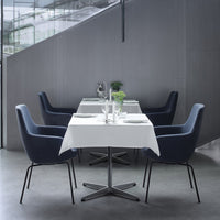 Elegant navy chairs around a white table, set against a modern grey interior for a sleek dining atmosphere.