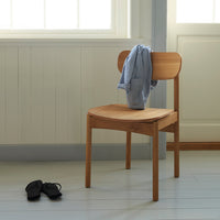 Stylish wooden chair with a natural finish, featuring a smooth seat and backrest; minimalist design complements any decor.