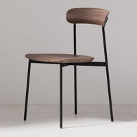 Alt text: Sleek black metal chair with a smooth walnut wood seat and backrest, showcasing minimalist design and natural color tones.
