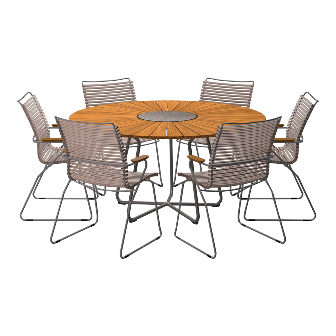 Round wooden dining table with a warm brown finish and six striped grey chairs, featuring a modern metal base.