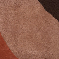 Textured rug featuring warm tones of beige, rust, brown, and terracotta in an abstract curved pattern.