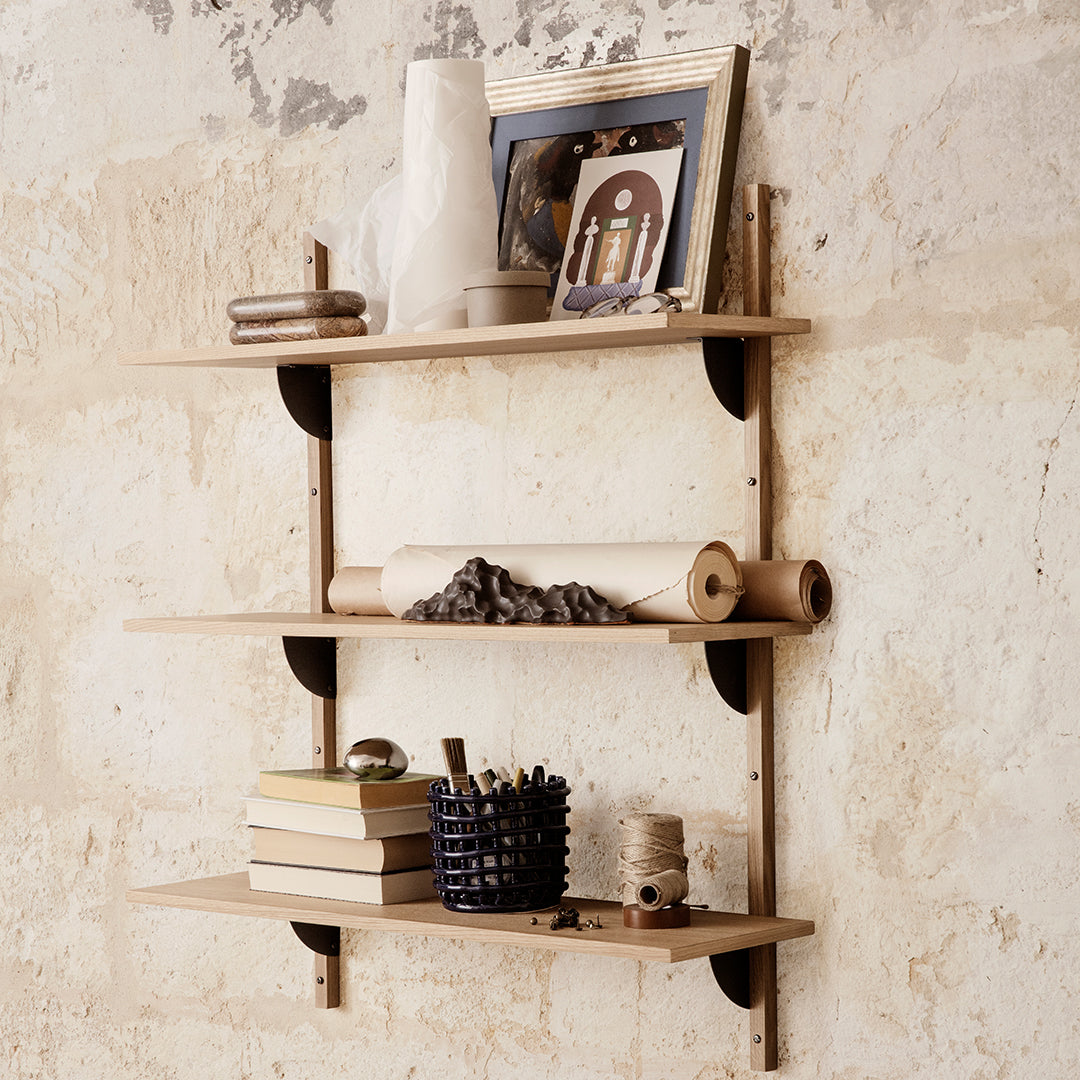Light wood shelves with black brackets, featuring neutral decor and a textured, white wall backdrop.