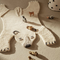 Cozy polar bear rug in soft cream with black accents, featuring a fluffy texture and playful animal patterns.
