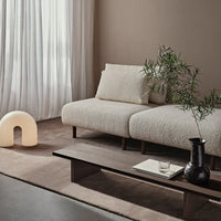 Textured off-white sofa with earthy tones and soft, neutral patterns in a modern living space.