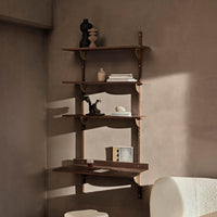 Wooden wall shelf with warm tones and smooth surfaces, featuring elegant brass brackets and minimalist decor accents.