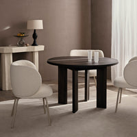 Round black wooden table with soft beige textured chairs, set against a neutral brown backdrop. Elegant and modern.