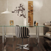Black and white striped chair showcased in a modern glass office setting with warm wood accents.