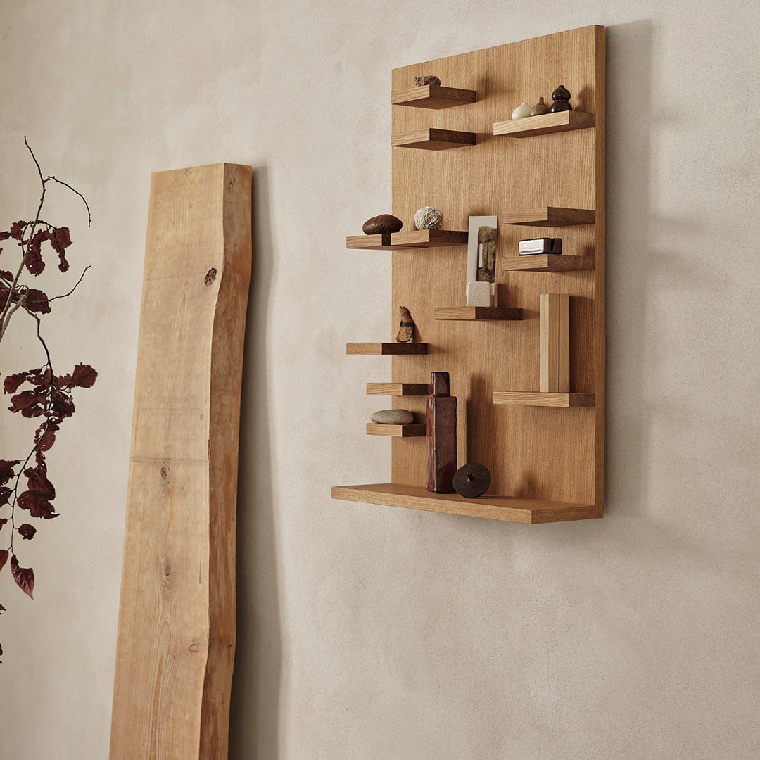 Natural wood wall shelf with light oak finish and various geometric patterns, complemented by a neutral background.