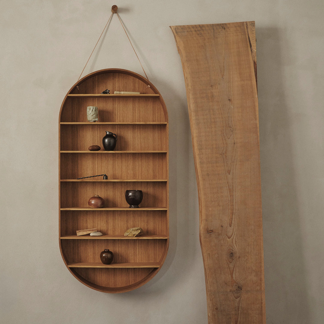 Oval wooden shelf with natural wood tones and minimalist design. Patterned texture from displayed decorative items.