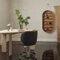 Modern workspace featuring earthy tones, a dark upholstered chair, and natural wood patterns for a minimalistic aesthetic.