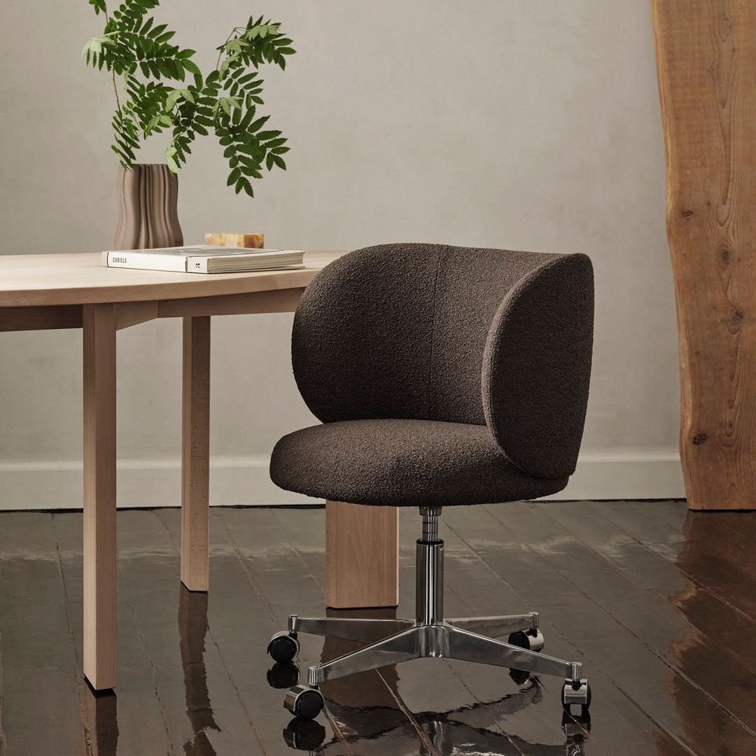 Brown upholstered swivel chair with a rounded back, complemented by a sleek silver base and a minimalist design.