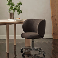 Brown upholstered swivel chair with a rounded back, complemented by a sleek silver base and a minimalist design.