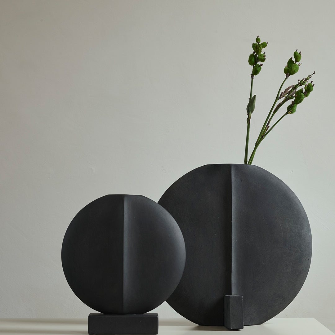 "Black geometric ceramic vases, featuring smooth finishes and contrasting shapes, perfect for modern decor."