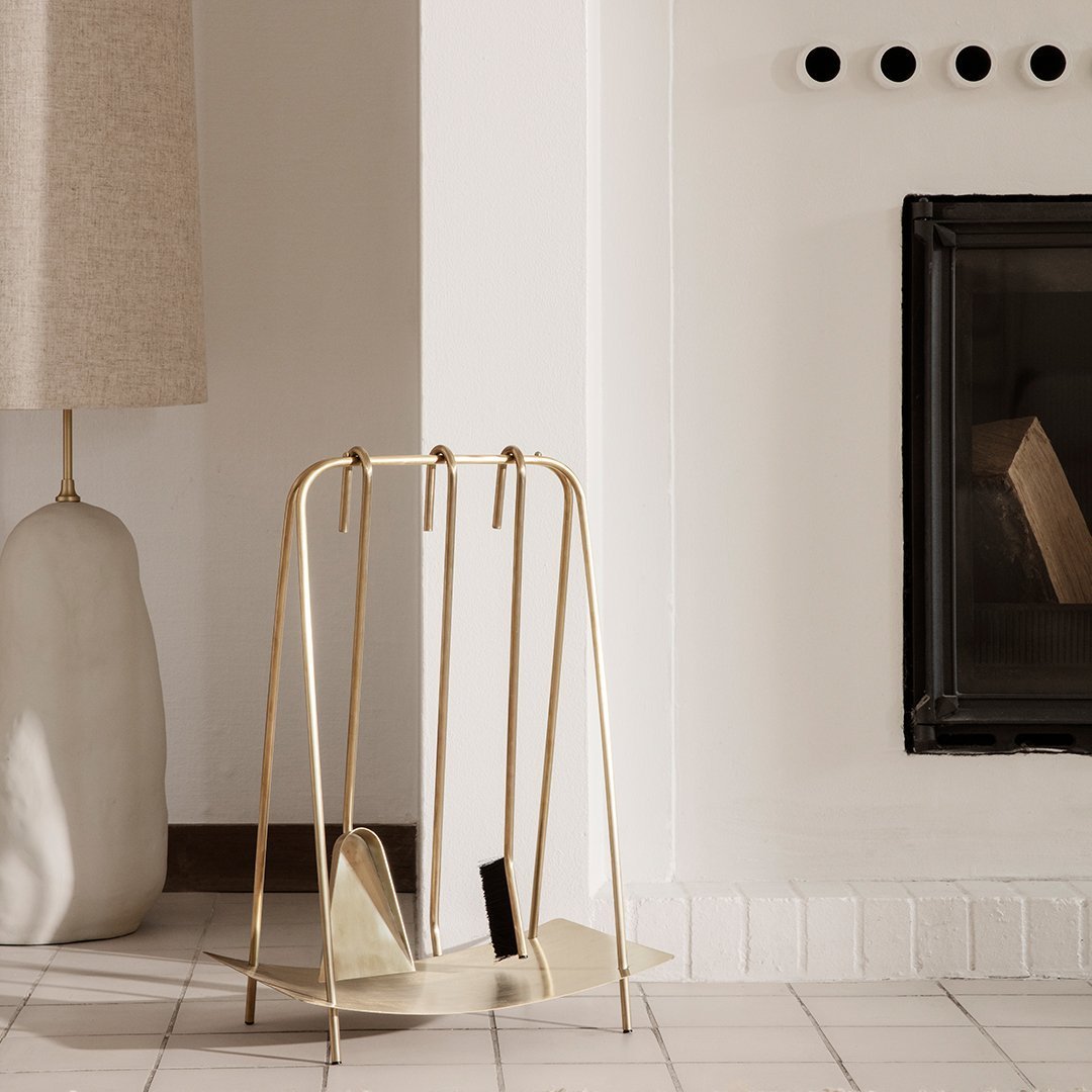 Gold metal magazine holder with a sleek, minimalist design, paired with neutral tones and soft textures in a modern living space.