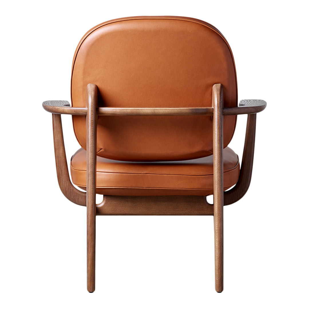 Brown leather chair with a smooth finish and minimalist wooden frame, showcasing a sleek and modern design.
