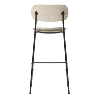 Beige fabric bar stool with a sleek black metal frame, featuring minimalistic design and subtle textures.