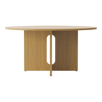 Round wooden dining table with a light oak finish and a simple, modern design featuring an oval cutout in the base.