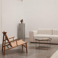 Neutral beige and soft white tones on a modern sofa and chair, complemented by a minimalist gray accent table.